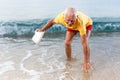 Glad elderly man touches the water temperature