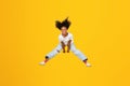Glad excited curly teen african american girl jumping, freezes in air, has fun on empty space Royalty Free Stock Photo