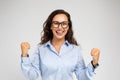 Glad excited pretty young european woman in glasses enjoy win, surprise, celebrate success in work