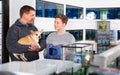 Glad father with son and little dog in petshop