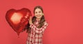 glad girl hold love heart balloon on red background