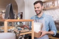 Glad handsome waiter putting cakes into the box. Royalty Free Stock Photo