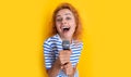 glad karaoke woman singer isolated on yellow background. young singer woman sing