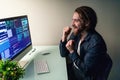 Glad bearded man programer working on computer with win gesture Royalty Free Stock Photo