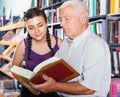 Glad mature man with girl are reading books Royalty Free Stock Photo