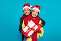 Glad millennial japanese man in hat hugs woman with box present, enjoy winter holidays, Xmas gifts