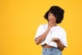 Glad pensive millennial african american curly woman in white t-shirt typing on smartphone Royalty Free Stock Photo