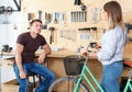 Man is consultating woman about her bicycle in the workshop. Royalty Free Stock Photo