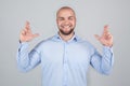 Glad positive bearded man crosses fingers, closes eyes with pleasure, anticipate hearing good news,  white background. Royalty Free Stock Photo