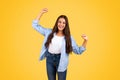 Glad pretty caucasian teenager lady student celebrates win, success, raise hands