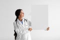 Glad pretty young hindu woman doctor in white coat with stethoscope hold large abstract empty space for words