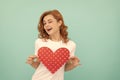 glad redhead woman hold red heart on blue background