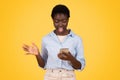 Glad shocked teen black lady student, typing on smartphone, in social networks, enjoy win