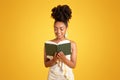 Glad smart pretty millennial black lady reading book alone, enjoy free time, planning day