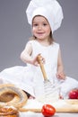 Glad and Smiling Caucasian Girl In Cook Uniform Making a Mix of Flour, Eggs and Vegetables Royalty Free Stock Photo