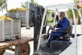 Male forklift driver unloading delivered grapes harvest from truck platform