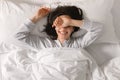 Glad smiling young european woman sleeping on white bed, waking up, enjoying vacation, good morning Royalty Free Stock Photo