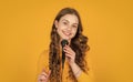 glad teen girl with microphone on yellow background