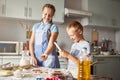 Joyous siblings making dough for cookies in well-equipped kitchen Royalty Free Stock Photo