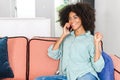 Glad to hear you. Happy excited young black woman with curly afro hair talking on the smartphone, has pleasant phone Royalty Free Stock Photo