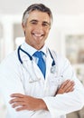 Glad to see youre feeling better. Cropped portrait of a handsome mature male doctor standing with his arms crossed in Royalty Free Stock Photo