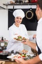 Glad woman cook giving salad to waitress Royalty Free Stock Photo