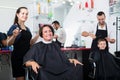 Glad woman hairdresser working with woman