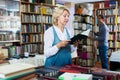 Glad woman reading book in book shop Royalty Free Stock Photo