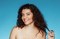 Glad young caucasian curly naked lady touching hair, enjoy beauty care result