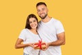 Glad young european guy hug wife, gives box present, enjoy holidays, birthday and New Year Royalty Free Stock Photo