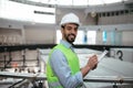 Glad young islamic professional man engineer builder with beard in protective clothing and hard hat makes notes Royalty Free Stock Photo