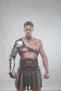 Gladiator in armour posing over grey background Royalty Free Stock Photo