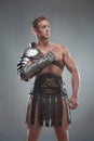 Gladiator in armour posing over grey background Royalty Free Stock Photo