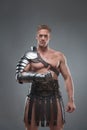 Gladiator in armour posing over grey background Royalty Free Stock Photo