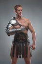 Gladiator in armour posing over grey background Royalty Free Stock Photo