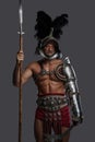 Gladiator in lightweight historical armor against grey studio background