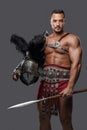 Gladiator in lightweight historical armor against grey studio background