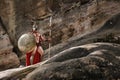 Gladiator with spear on rocks Royalty Free Stock Photo