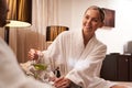 Gladsome woman with jar of natural lemonade looking friendly