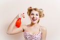 Glamor dehydration: gorgeous funny blond pinup lady having fun holding sprinkler and spraying in mouth looking at camera