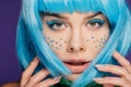 Glamor girl with blue wig, makeup and stars on face, isolated