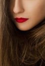 Glamorous beauty face closeup of a woman with classy makeup look and bright lipstick, brunette girl with long hair