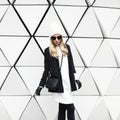 Glamorous blonde standing at the wall. Urban fashion black and w