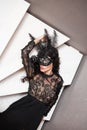 Glamorous brunette lady with a beautiful hairstyle and red lips, in an evening dress, a Venetian black mask with stylish accessori Royalty Free Stock Photo