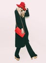 Glamorous fashion blond girl in classic black coat and red hat. Royalty Free Stock Photo
