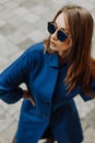 Beautiful young woman in stylish glasses and in a trendy blue coat Royalty Free Stock Photo