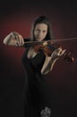 Glamorous girl with a long brown hair playing the violin