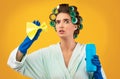 Glamorous Housewife Holding Detergent Bottle And Cleaning Sponge, Yellow Background