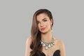 Glamorous jewelry woman brunette fashion model with gold diamond earning and luxury necklace posing against gray studio wall Royalty Free Stock Photo