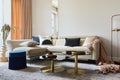 Glamorous living room interior design with modern beige sofa, glass coffee table, red armchair and golden accessories. Template. Royalty Free Stock Photo